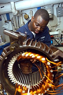 US Navy 040902-N-7683J-003 Electrician's Mate 3rd Class Tayo Gbadebo from Lagos, Nigeria, rewires the motor from an Aqueous Film Forming Foam (AFFF) Sprinkler System's pump.jpg